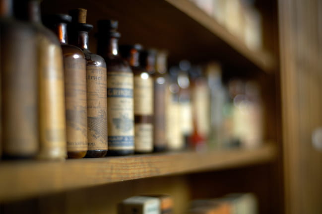A row of historic pharmaceutical bottles on display at the MUSC College of Pharmacy Museum