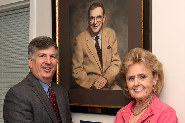 Dean Hall and Alycia Araneo Craft next to the portrait of her father