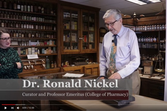 Ron Nickel demonstrating equipment in pharmacy museum 